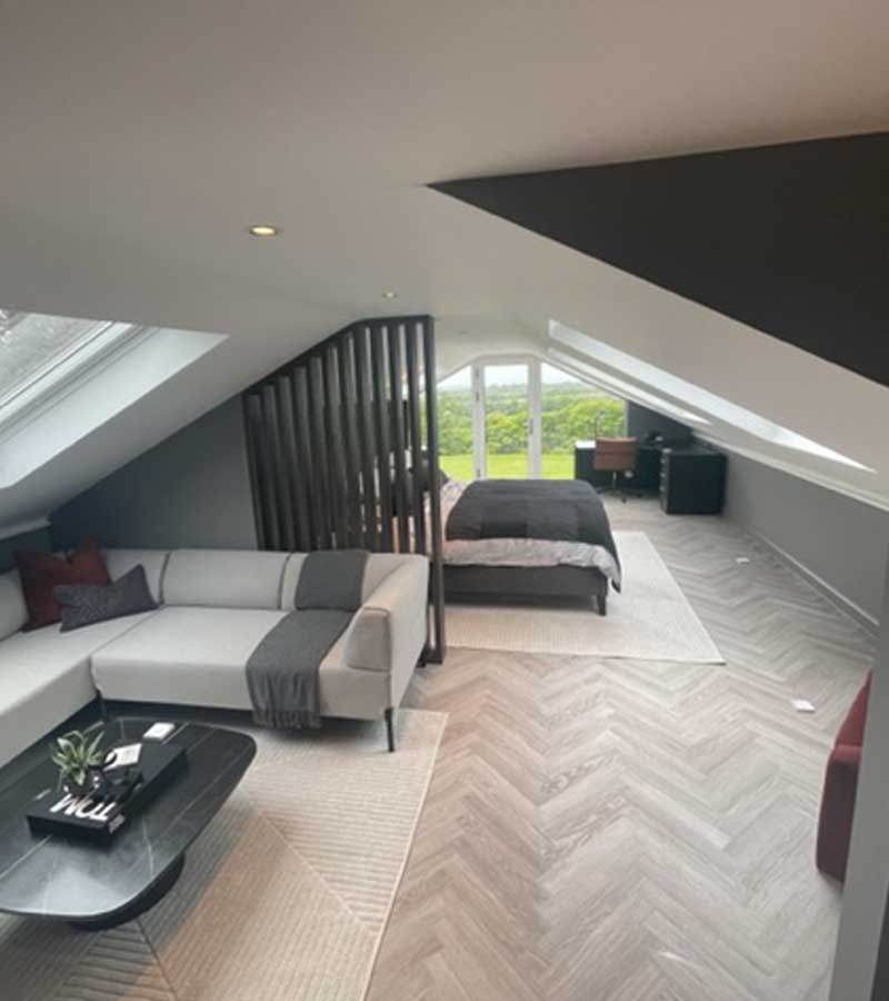 A stylish large velux loft conversion bedroom with additional furniture built by topflite loft conversions in northwest england uk